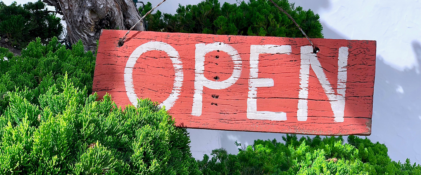 a wooden hanging "open" sign