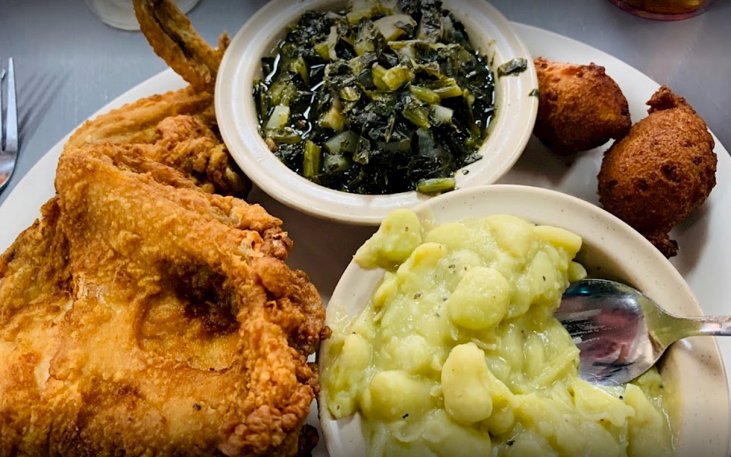 fried chicken, greens, and green beans with hush puppies