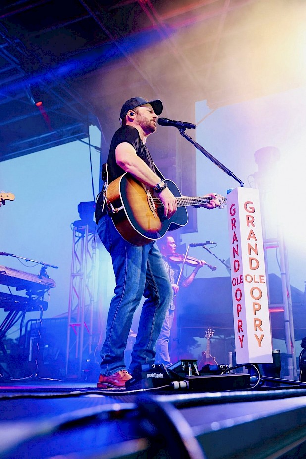 country artist signing on a stage with a guitar