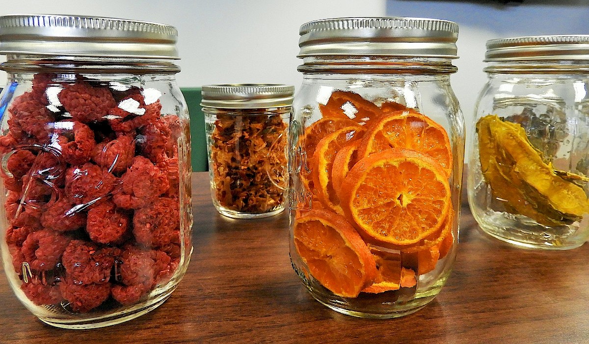 dehydrated fruit in mason jars on a wooden table