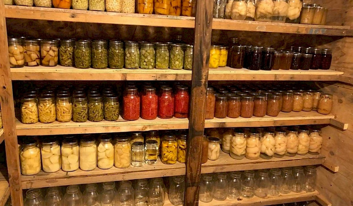 canning jars full of fresh produce on pantry shelves