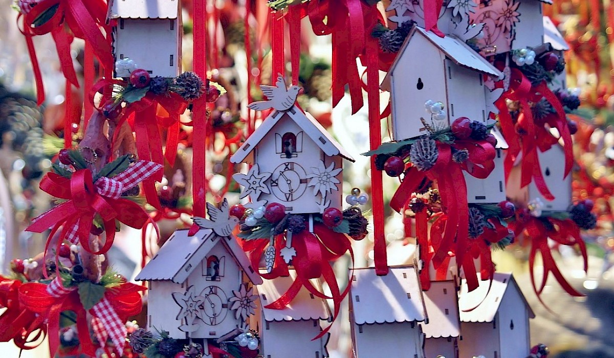 white bird houses hung with red ribbons