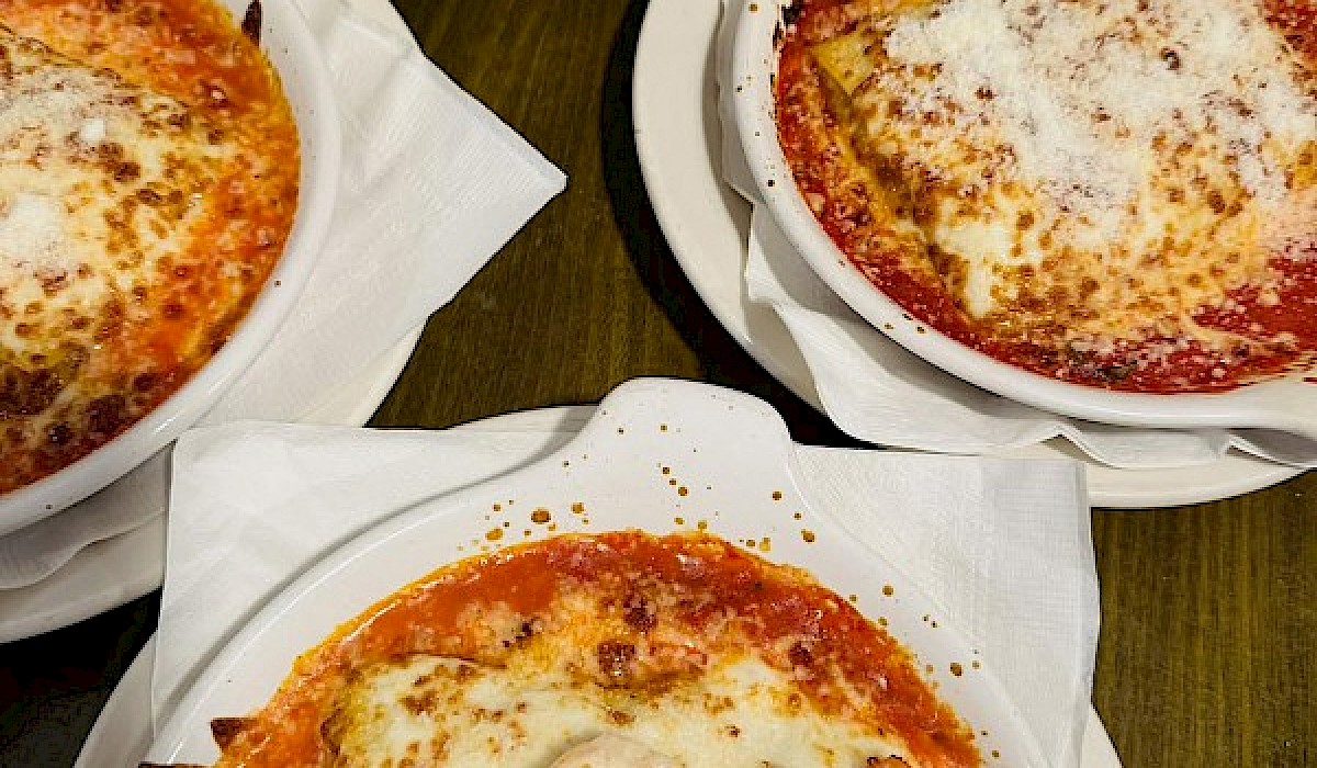 dishes of homemade lasagna sitting on a restaurant counter