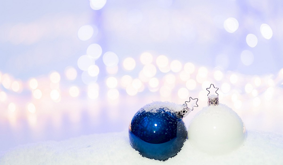blue and white christmas ornaments sitting on snow