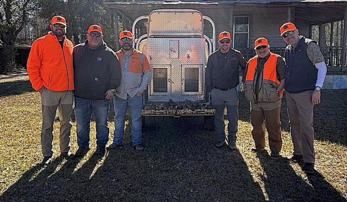 hunters getting ready to go on a hunt standing in front of a hunting lodge