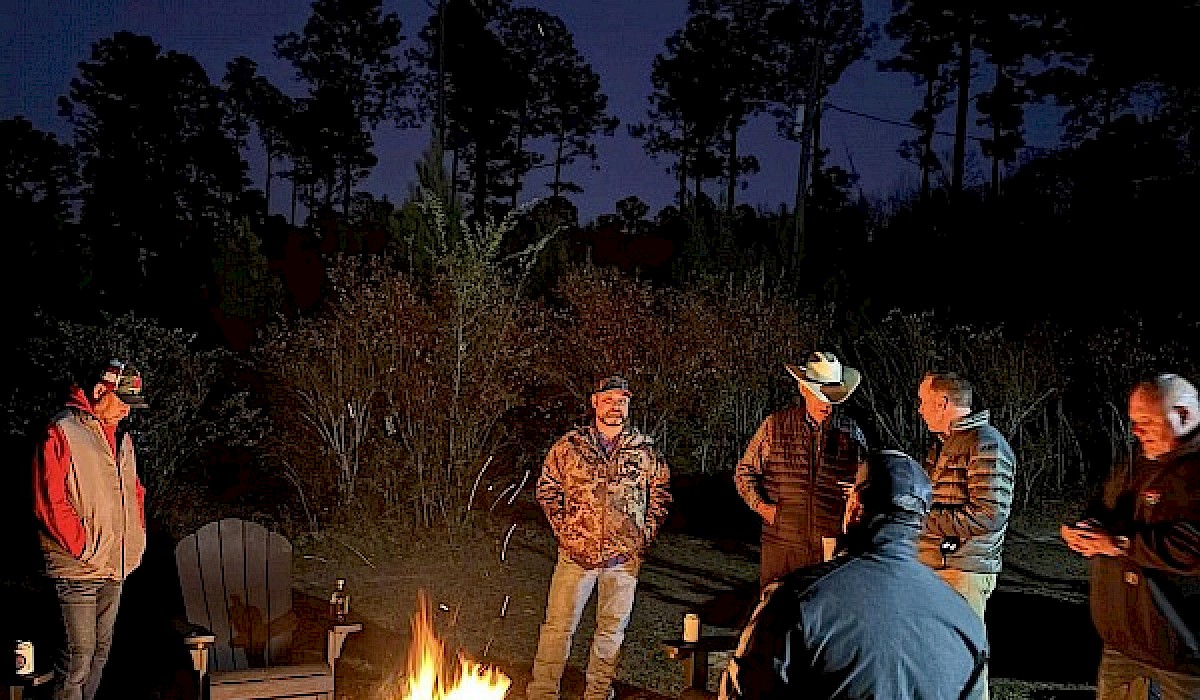 hunters gathered around a firepit at the end of a hunt on a quail hunting preserve