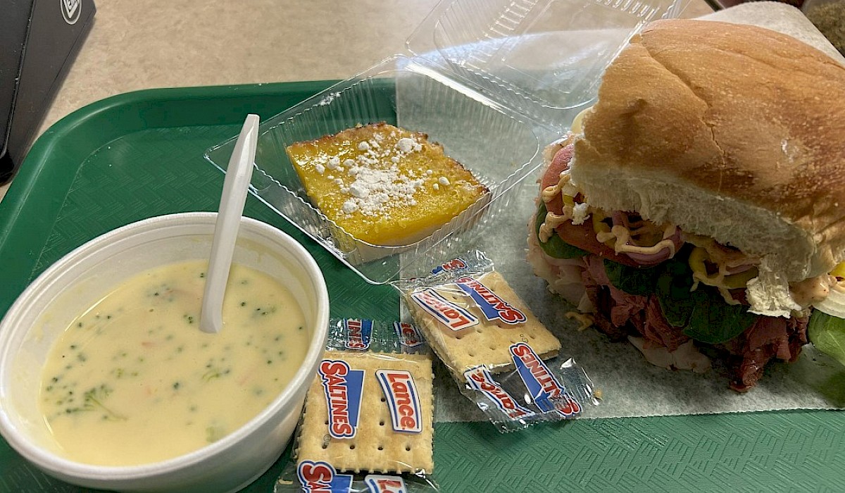 sandwich and soup combo meal sitting on a sandwich shop table