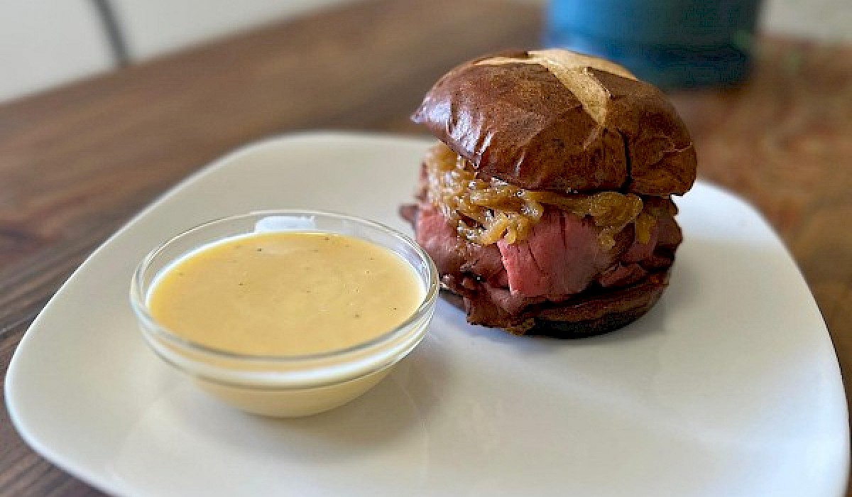 roast beef sandwich with soup sitting on a sandwich shop table