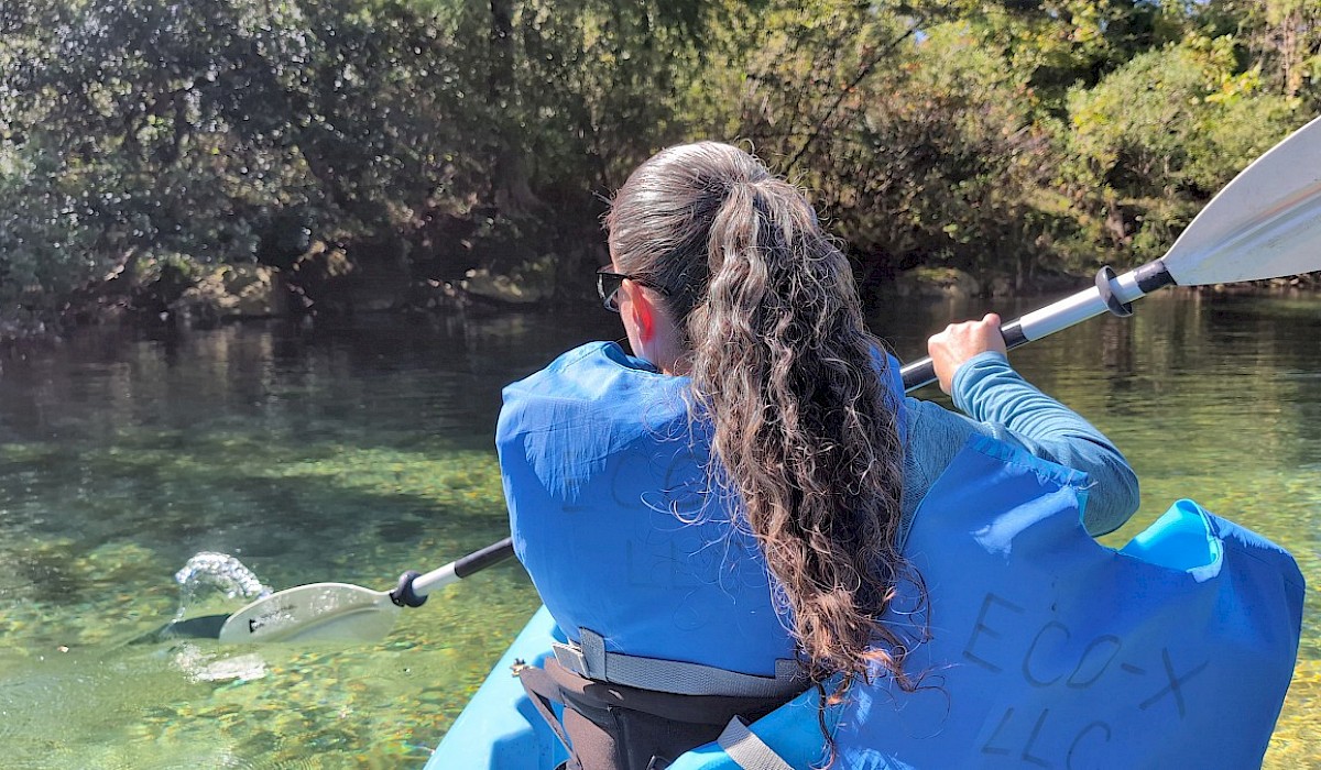 woman paddling a kayak on a creek