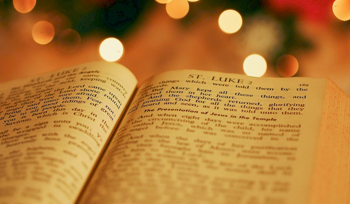 the Bible opened to Luke sitting on a table