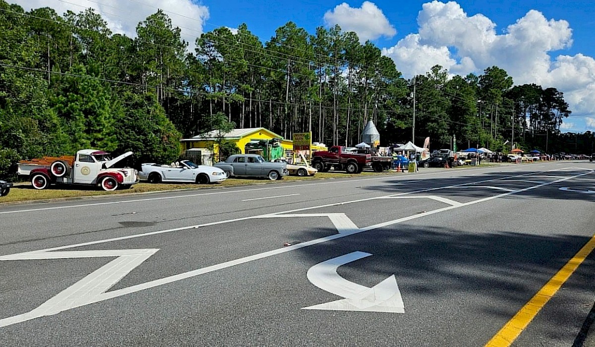 car show displayed on green lawn in front of local restaurant